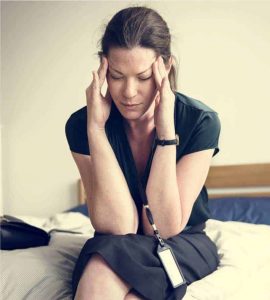 a stressed out woman holding head